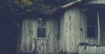 an old run down house with a broken window