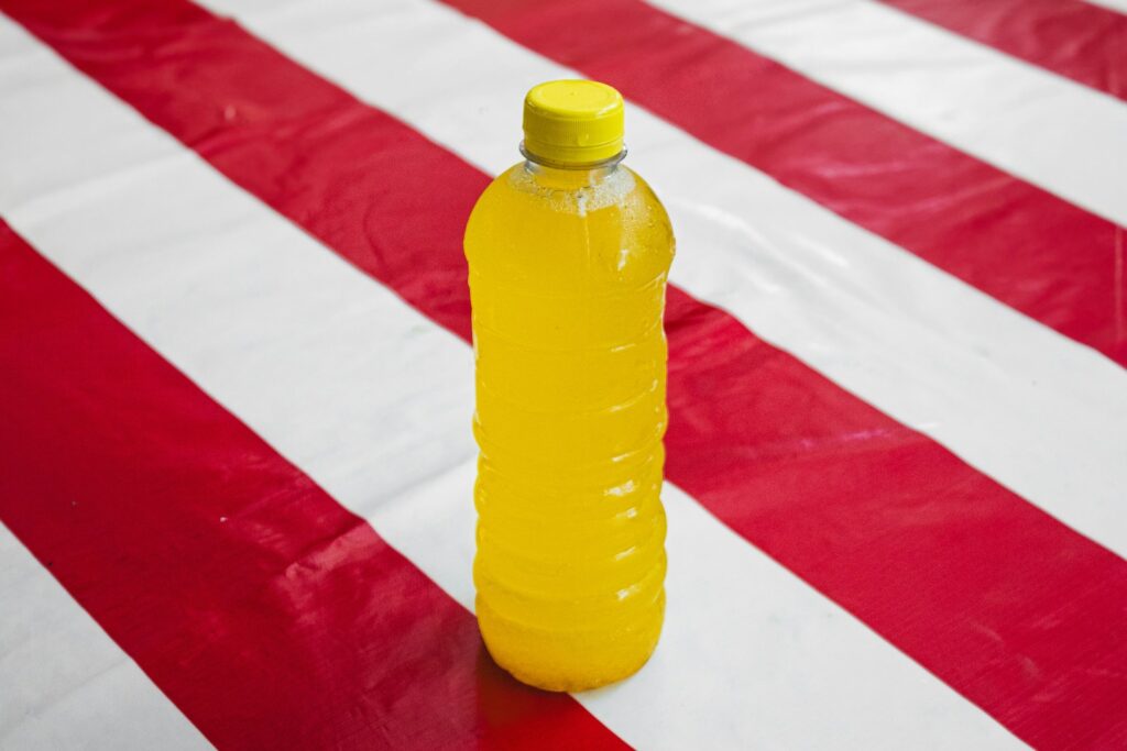 A plastic bottle sitting on top of a red and white striped table cloth
