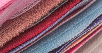 Here's a short caption: close-up of colorful stacks of fabric.