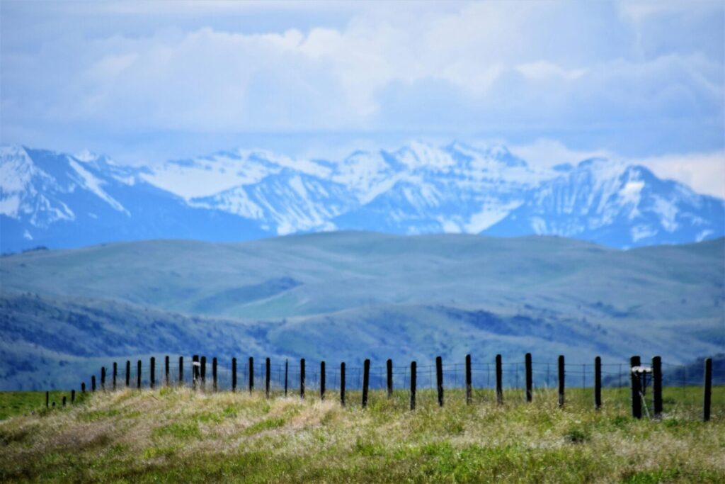 A breathtaking view of the snow-capped mountains and open fields in Harrison, Montana.
