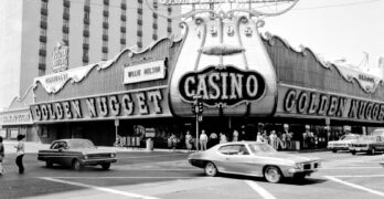 grayscale photo of cars parked near building