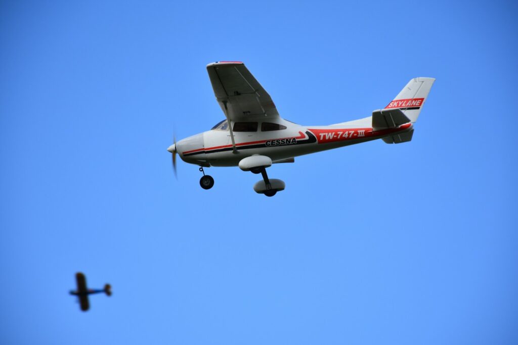 white and red biplane under blue sky