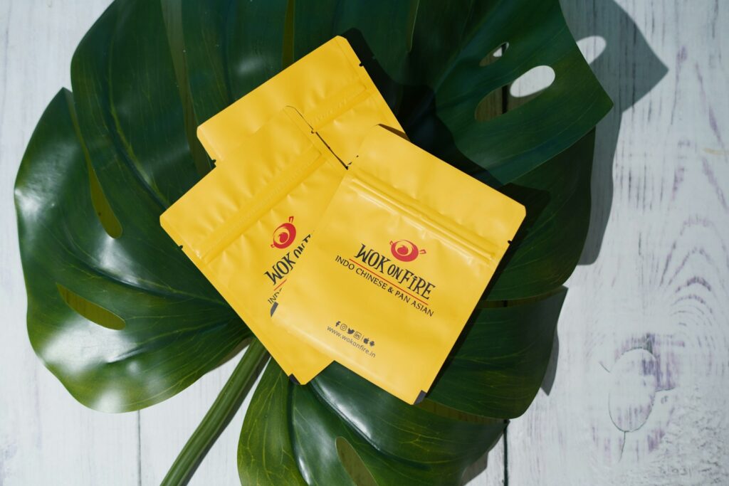 a couple of bags of yellow tea sitting on top of a green leaf