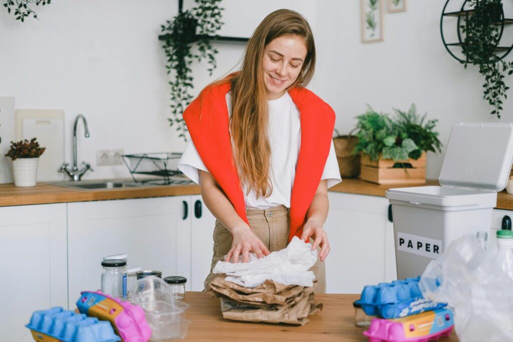 Woman sorts recyclables in the kitchen; promoting eco-friendly habits.