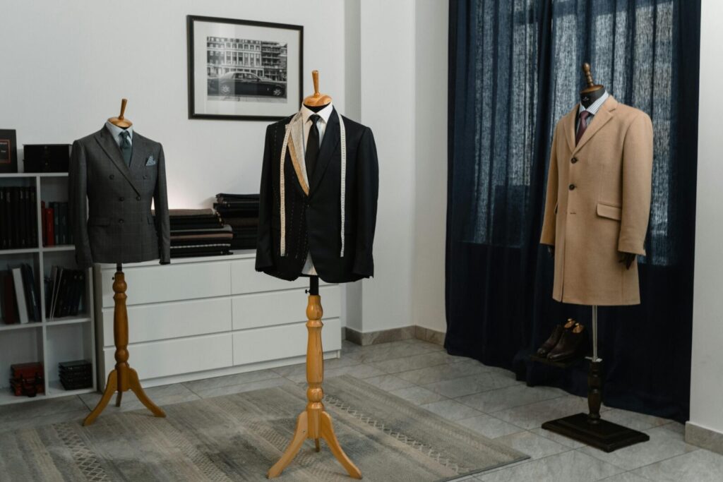 Stylish men's suits on mannequins in an atelier, showcasing luxury tailoring.