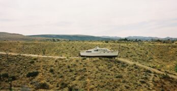 white and black boat on green grass field during daytime