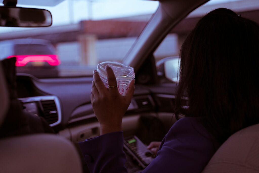 woman in black long sleeve shirt holding clear plastic cup