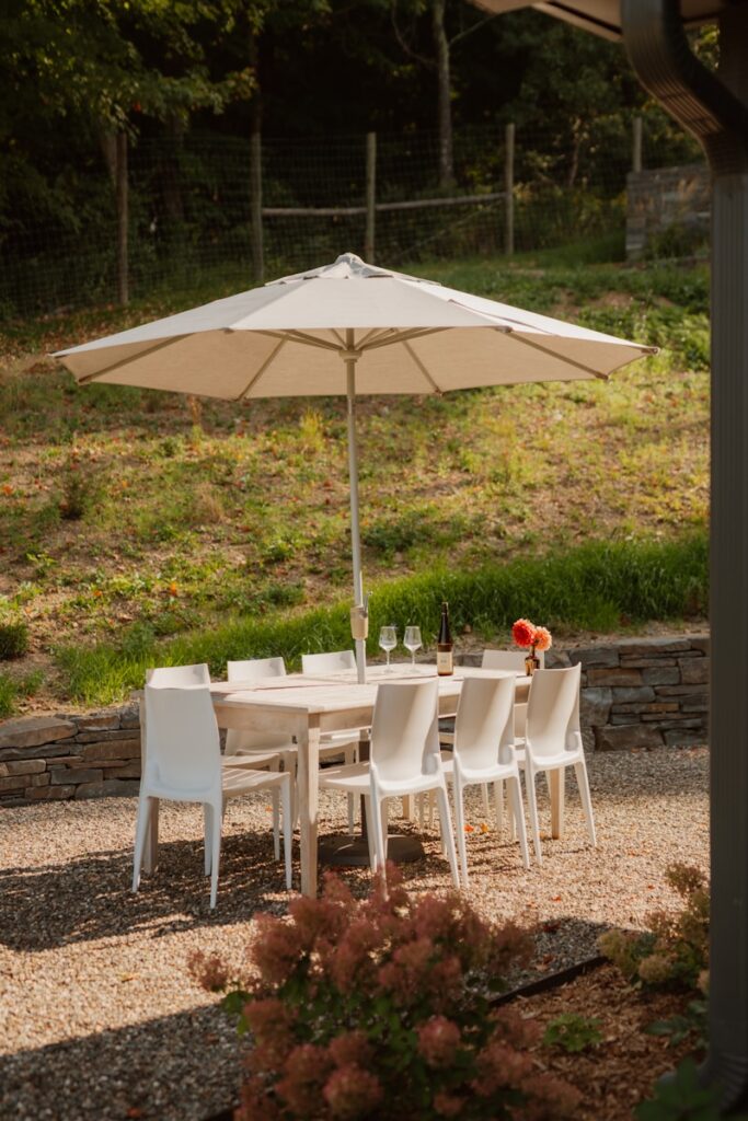 Outdoor dining table set with umbrella and chairs.