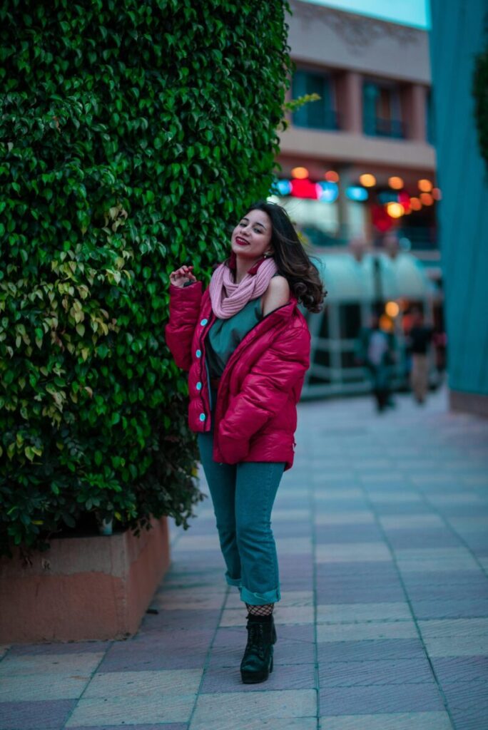 Woman in winter jacket smiling while enjoying an urban winter setting.