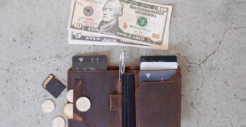 10 us dollar bill beside black leather wallet and coins