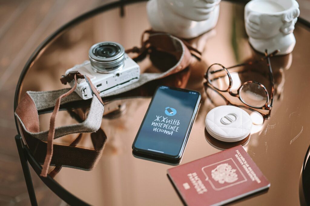 a table topped with a camera and a cell phone