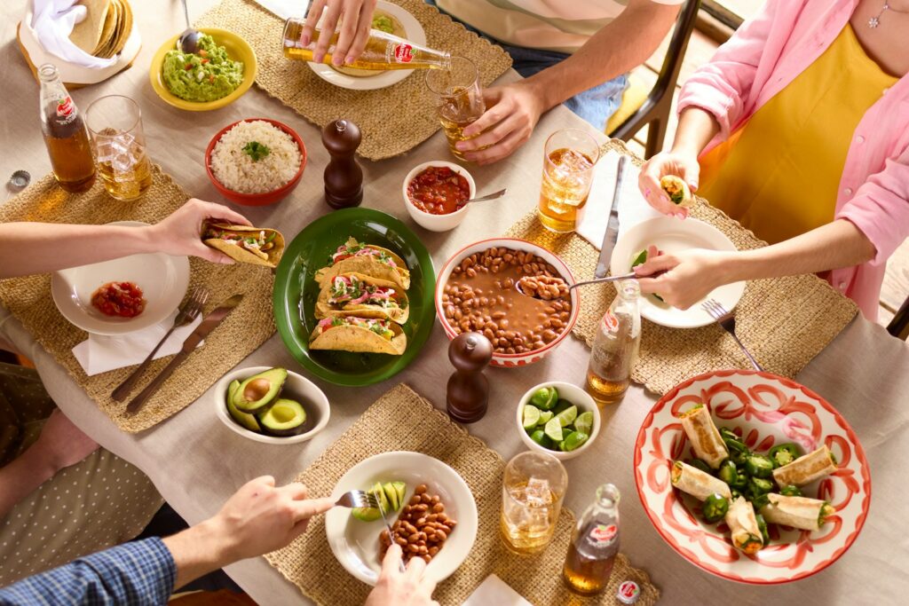 People are gathered around a table, enjoying a mexican feast.