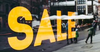 man in green jacket walking on sidewalk during daytime