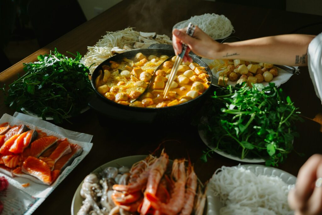 Table filled with ingredients for hot pot meal.