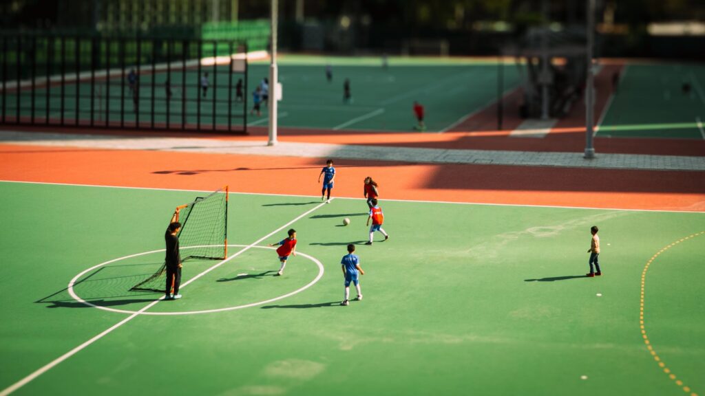 People playing soccer on a green outdoor court.