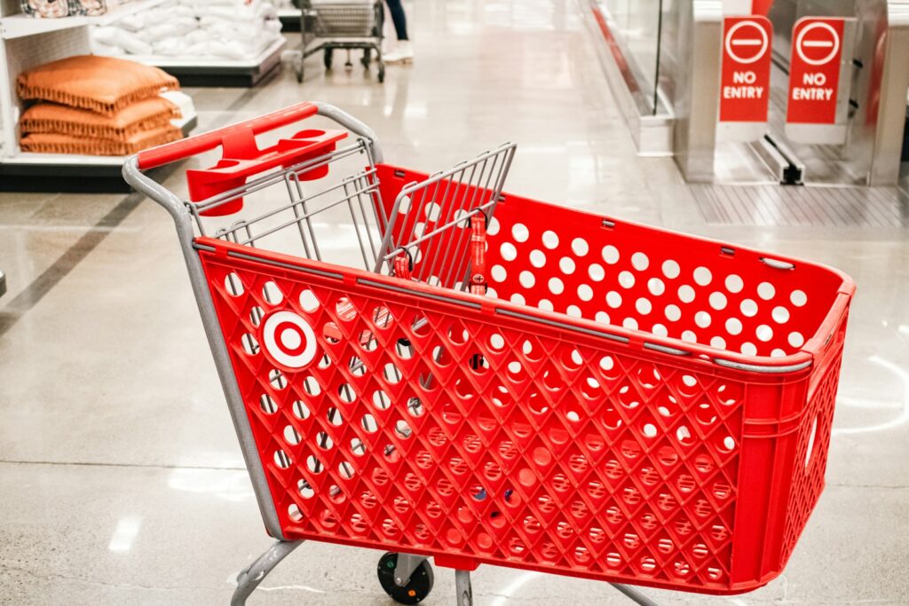 A red target shopping cart sits in a store.