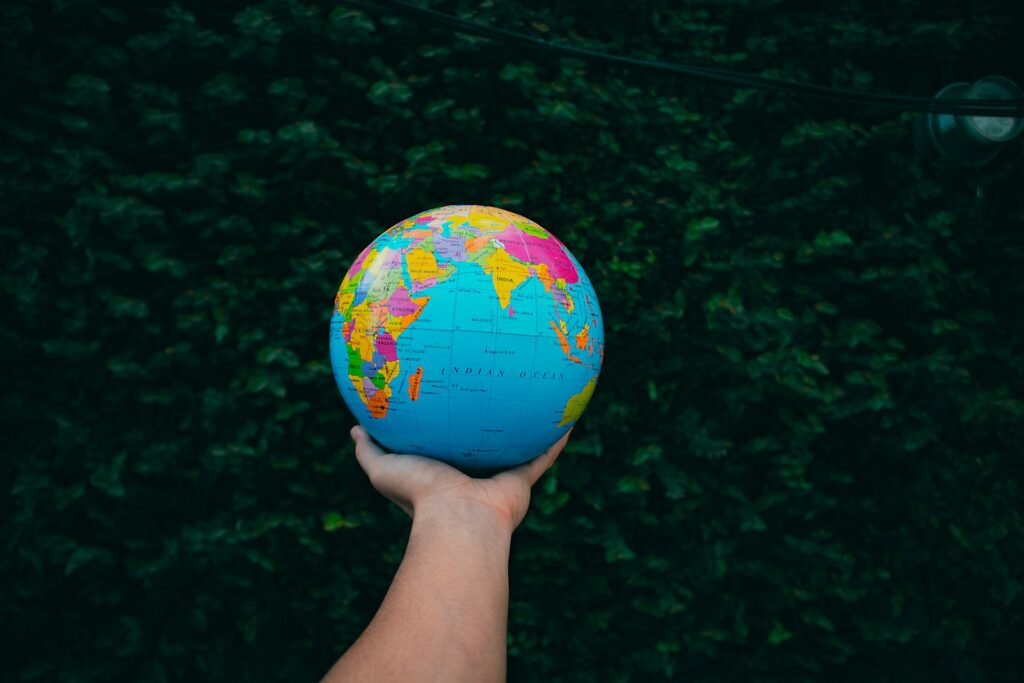 a person holding a small globe in their hand