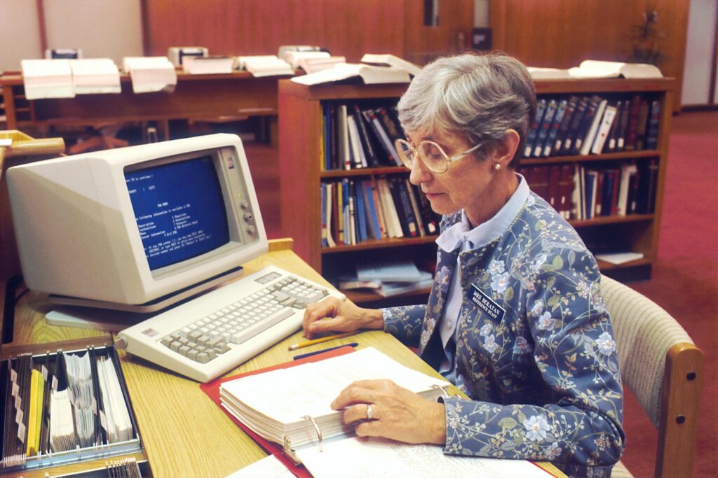 woman sitting at desk with desktop computer
