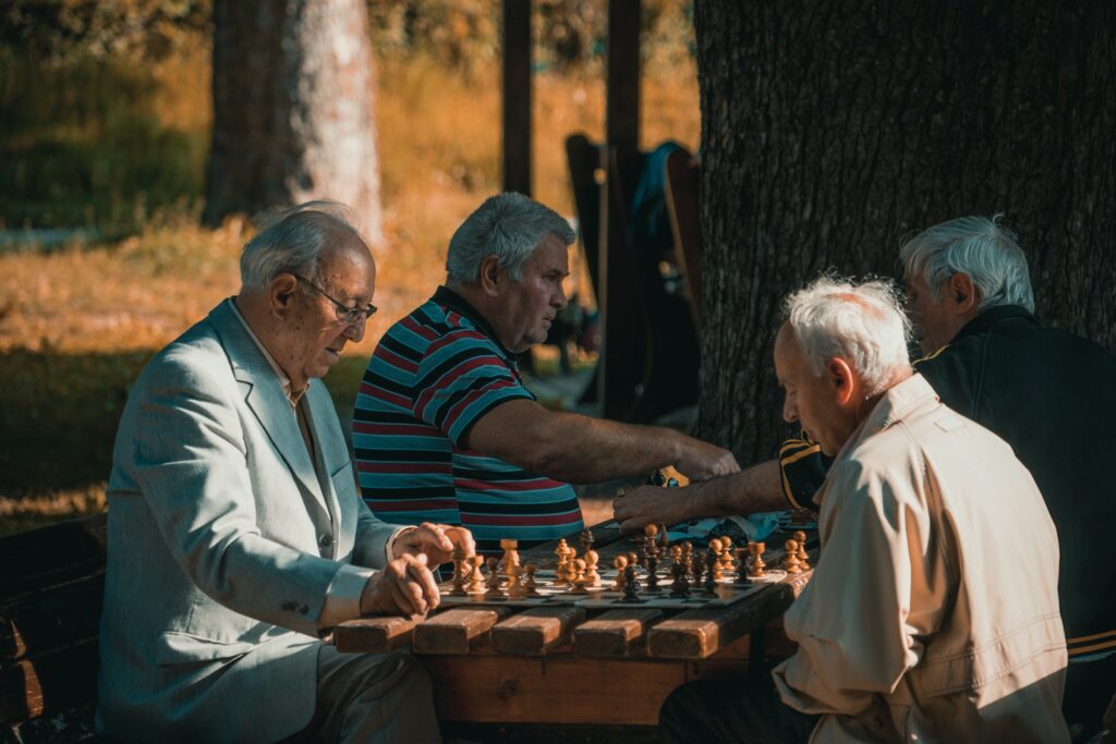 group of men playing chess under trees