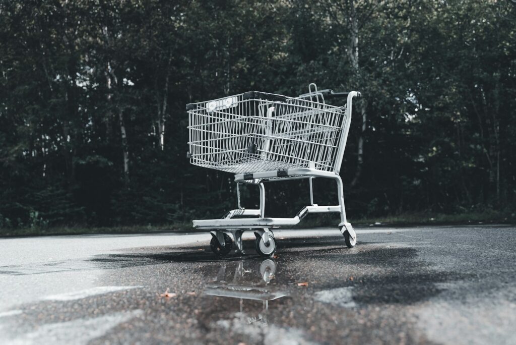 A shopping cart sitting in the middle of a parking lot