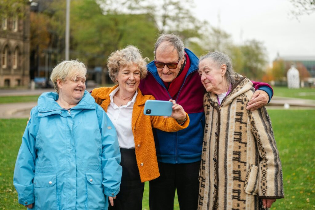 Four seniors taking a selfie outdoors